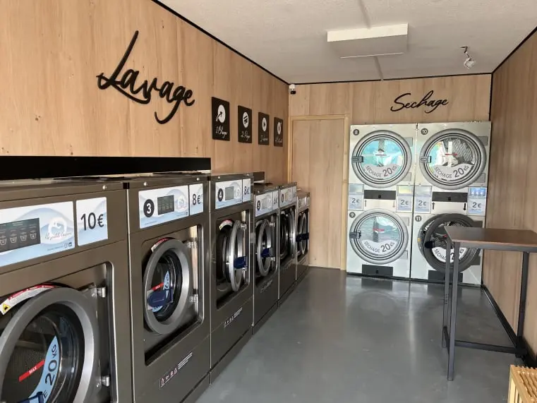 Intérieur d’une laverie automatique équipée de machines professionnelles